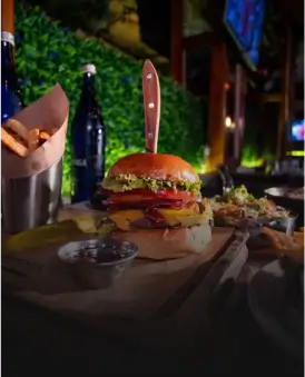 there is a hamburger and fries on a table with a bottle of beer