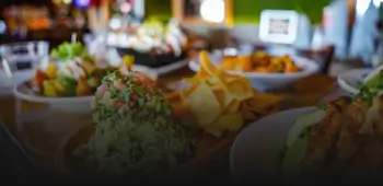 there are many plates of food on the table with chips