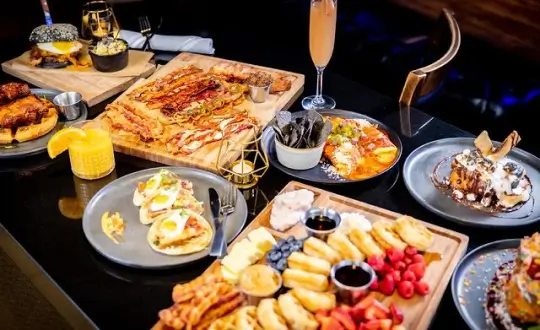 there are many plates of food on the table with drinks